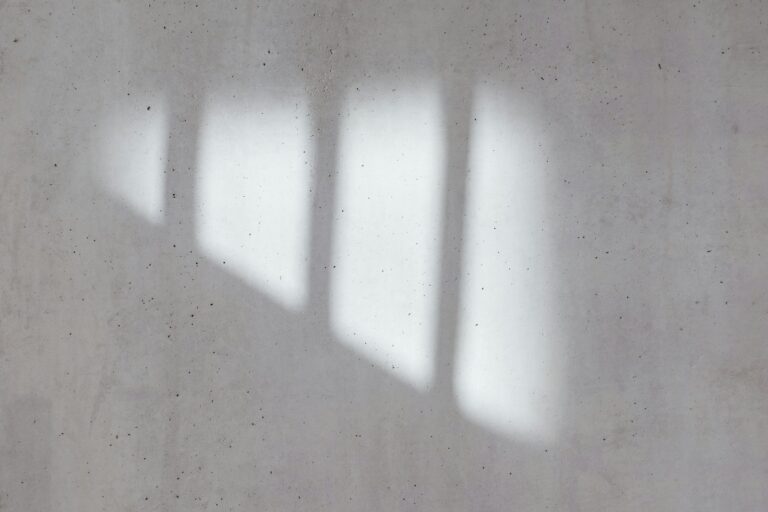 Window light falling across an empty concrete wall